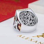 White gold ring with intricate design roman motif pattern on a red and white background