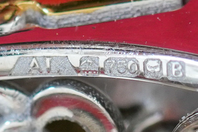 close up image of alexandria's and goldsmiths hallmarks on 18k gold metal